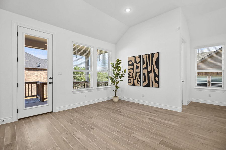 Empty room with light wood finished floors, vaulted ceiling, and recessed lighting