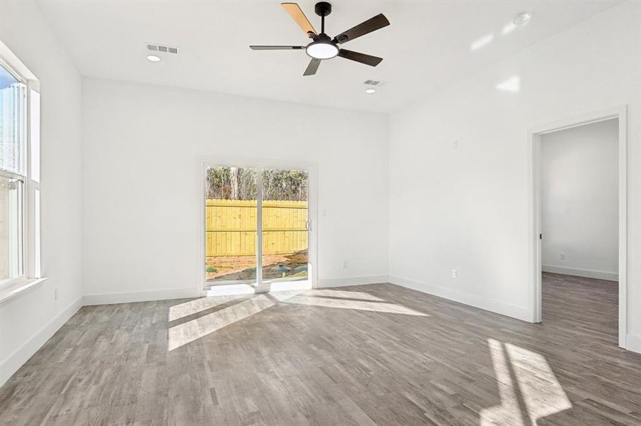 Spare room with a healthy amount of sunlight, visible vents, and wood finished floors