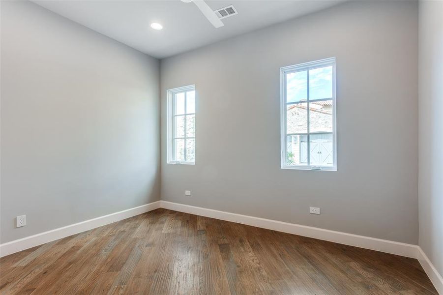 Empty room featuring a wealth of natural light and hardwood / wood-style floors