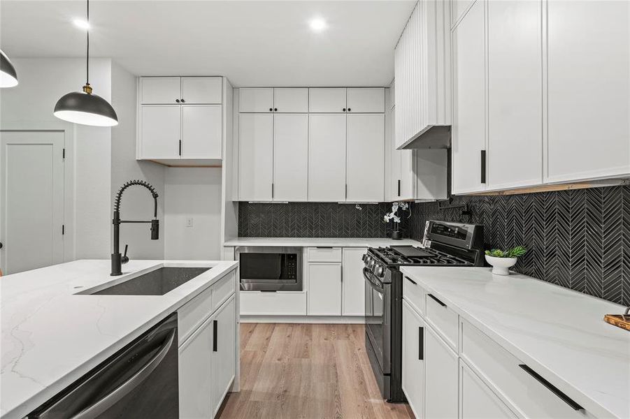 Kitchen with white cabinets and decorative light fixtures