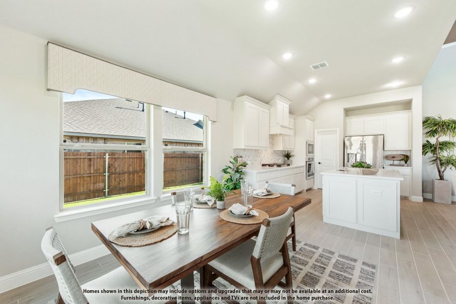 Open dining area with wood table next to kitchen featuring white cabinets, island, and large windows Open dining area with wood table next to kitchen featuring white cabinets, island, and large windows
