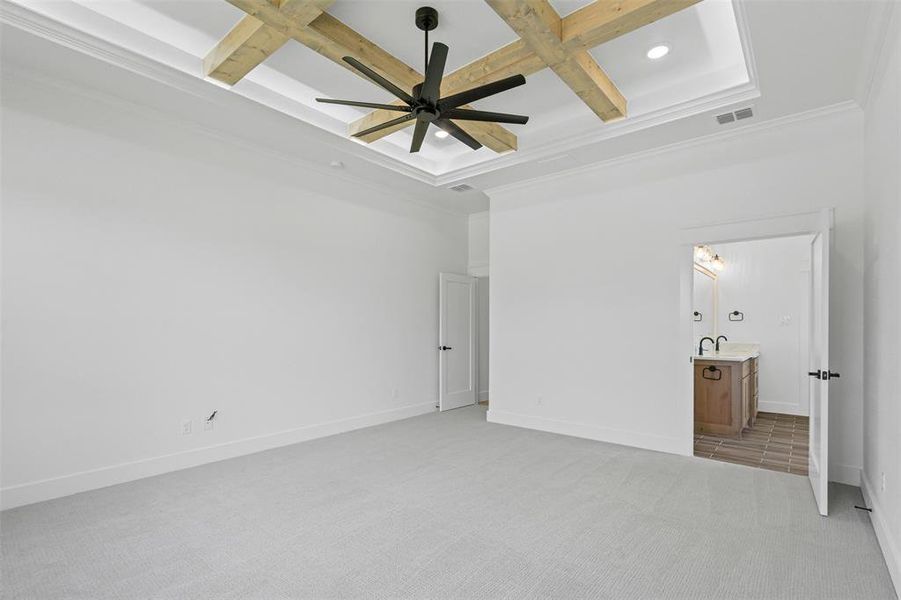 Unfurnished bedroom with coffered ceiling, beam ceiling, light colored carpet, crown molding, and recessed lighting Unfurnished bedroom with coffered ceiling, beam ceiling, light colored carpet, crown molding, and recessed lighting