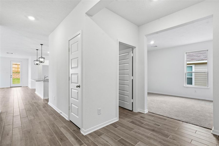 Flowing entry hallway featuring durable tile flooring, providing access to essential areas like the laundry room before opening up to the versatile Den. Flowing entry hallway featuring durable tile flooring, providing access to essential areas like the laundry room before opening up to the versatile Den.