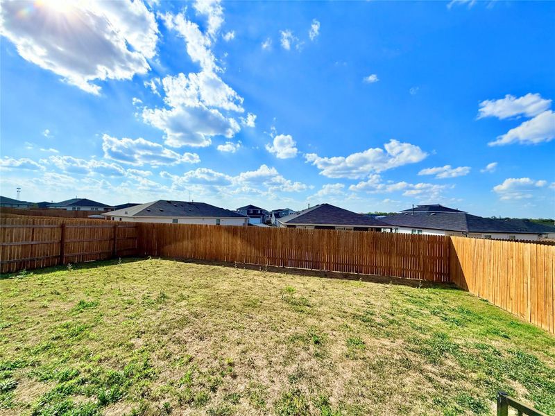 Fenced backyard with a residential view Fenced backyard with a residential view