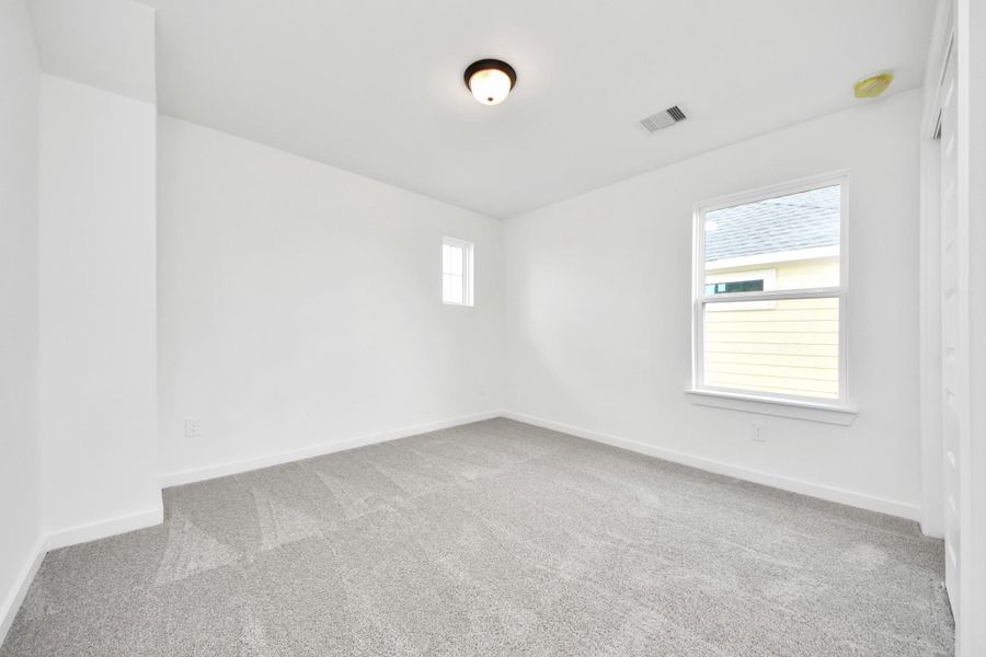 Secondary bedroom features plush carpeting, large windows that let in plenty of natural light, bright paint, and spacious closets. Secondary bedroom features plush carpeting, large windows that let in plenty of natural light, bright paint, and spacious closets.