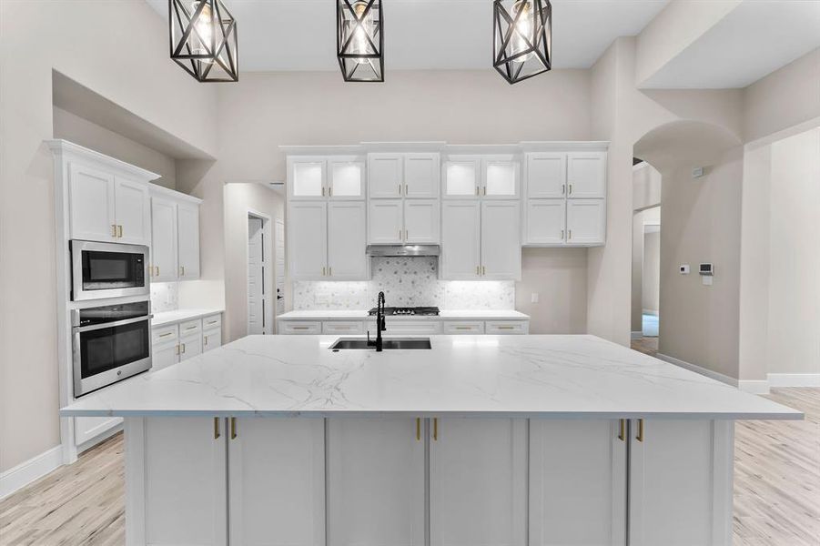 Sleek kitchen with  quartz countertops, huge kitchen island, and stainless appliances!