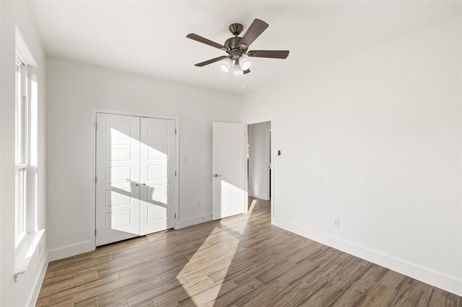 Unfurnished room with ceiling fan and light hardwood / wood-style floors