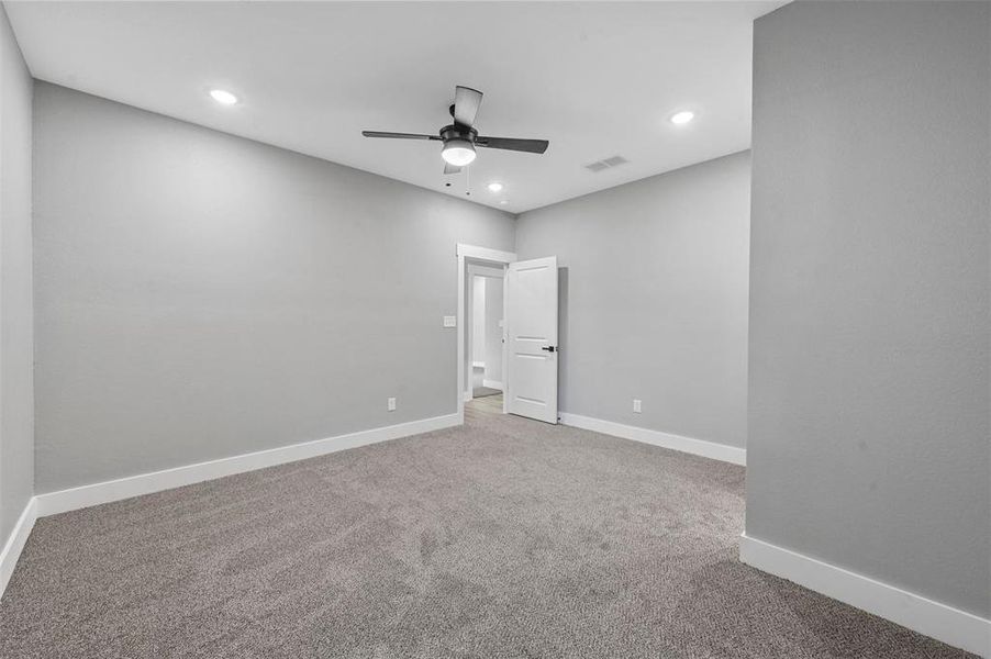 Carpeted empty room featuring ceiling fan