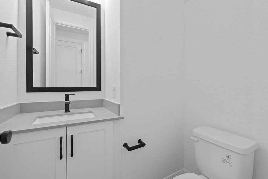 Half bath featuring vanity and toilet