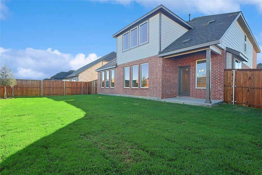 Rear view of property with a patio area, a fenced backyard, a shingled roof, and brick siding Rear view of property with a patio area, a fenced backyard, a shingled roof, and brick siding