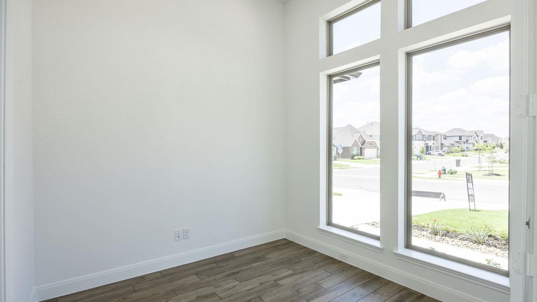 Unfurnished room with a residential view and dark wood-type flooring Unfurnished room with a residential view and dark wood-type flooring