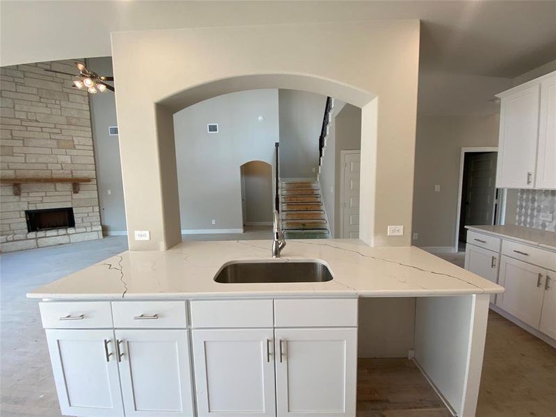 Kitchen island with stainless single basin sink and Brushed Nickel Delta extendable faucet.