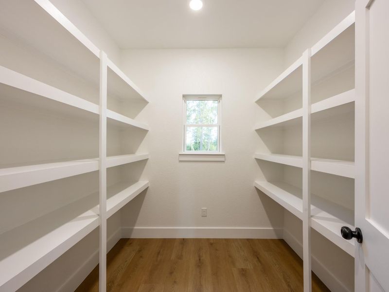 Storage is never an issue with this walk-in pantry featuring built-in shelving and a window for natural light—perfect for keeping your kitchen essentials organized and within reach. Storage is never an issue with this walk-in pantry featuring built-in shelving and a window for natural light—perfect for keeping your kitchen essentials organized and within reach.