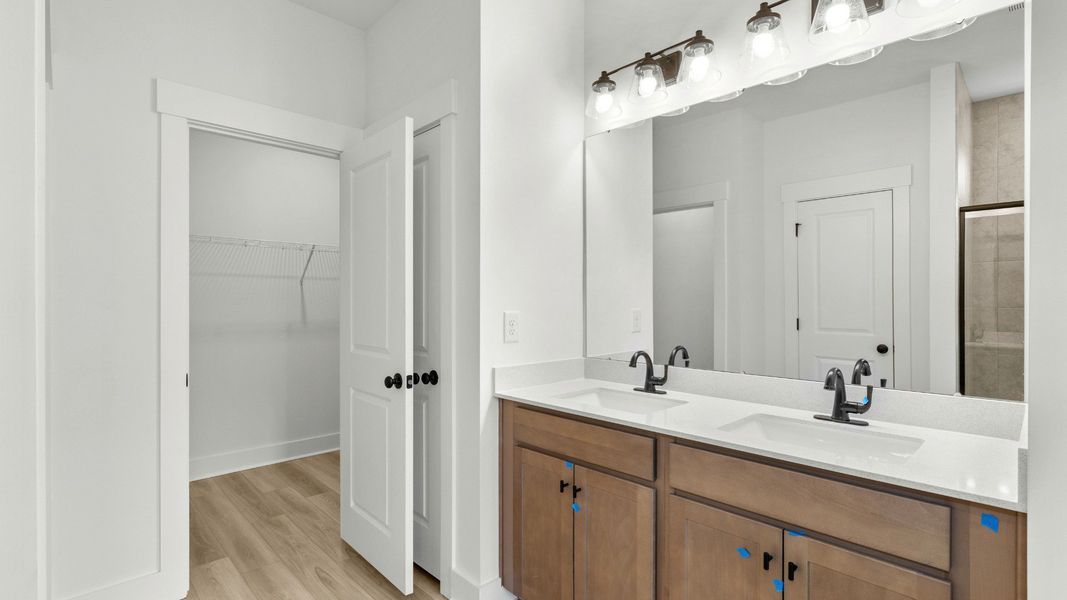 Primary bath with quartz counters and dual sinks at Chestnut Farms by DRB Homes