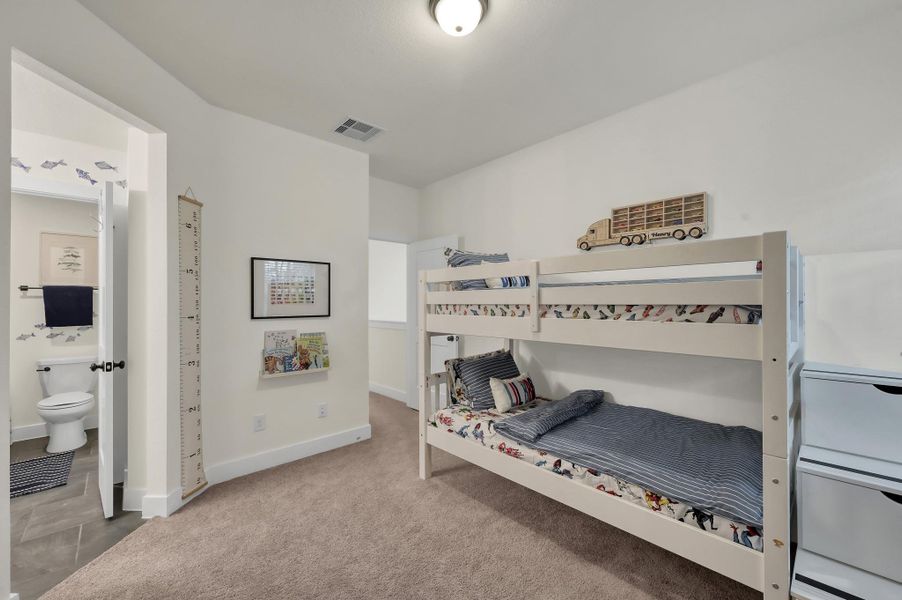 Spacious secondary bedroom featuring its own private vanity and connected restroom for added comfort and convenience.