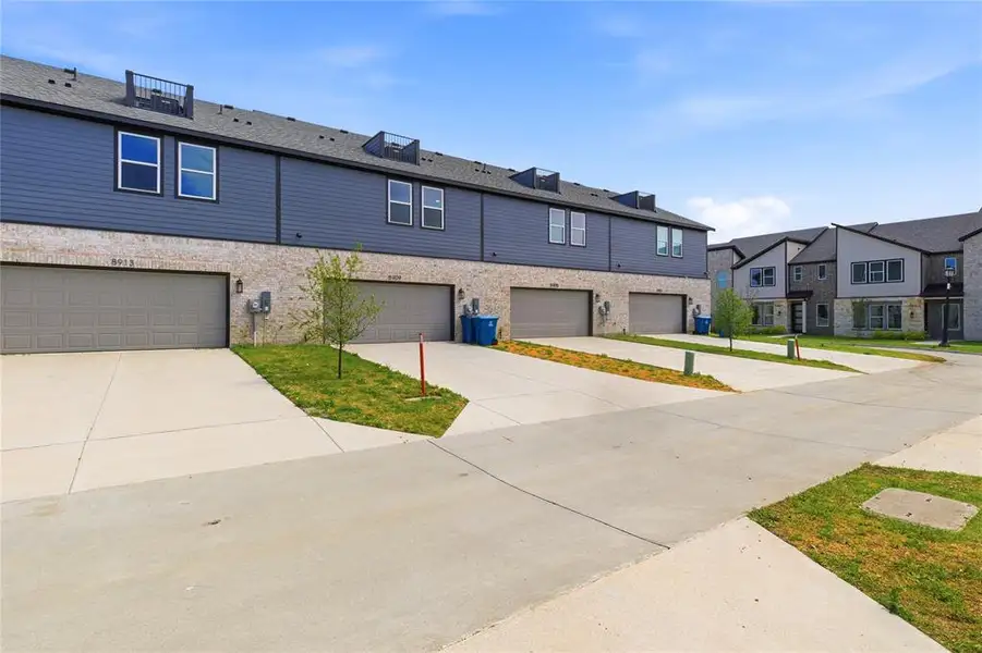 View of front of house featuring driveway, a garage, and a residential view
