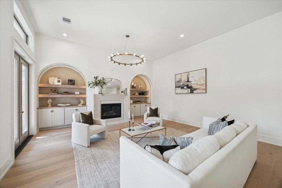 Additional view of the living room featuring an elegant 15-light, 50-inch-wide abstract ring chandelier.