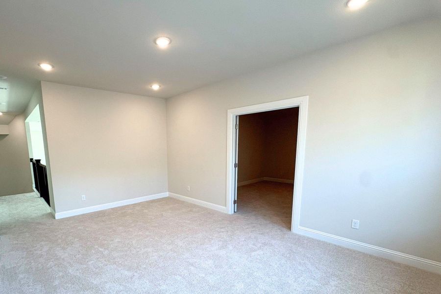Carpeted bonus room featuring recessed lighting and neutral wall tones
