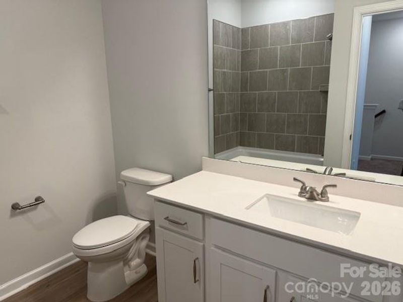 Hall bath also features modern finishes and quartz counters