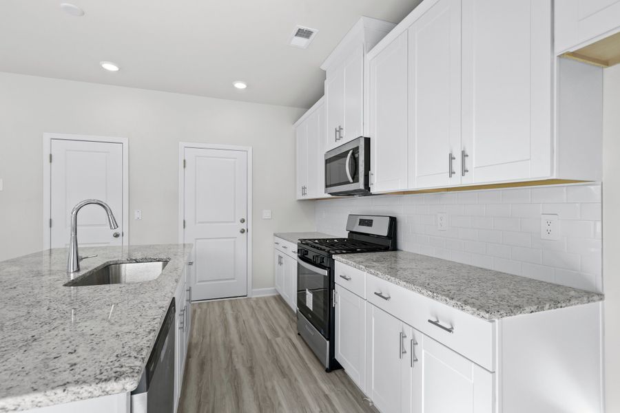 The large kitchen features stunning finishes and a walk-in pantry. The large kitchen features stunning finishes and a walk-in pantry.