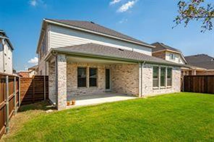 Rear view of property with a patio and a lawn