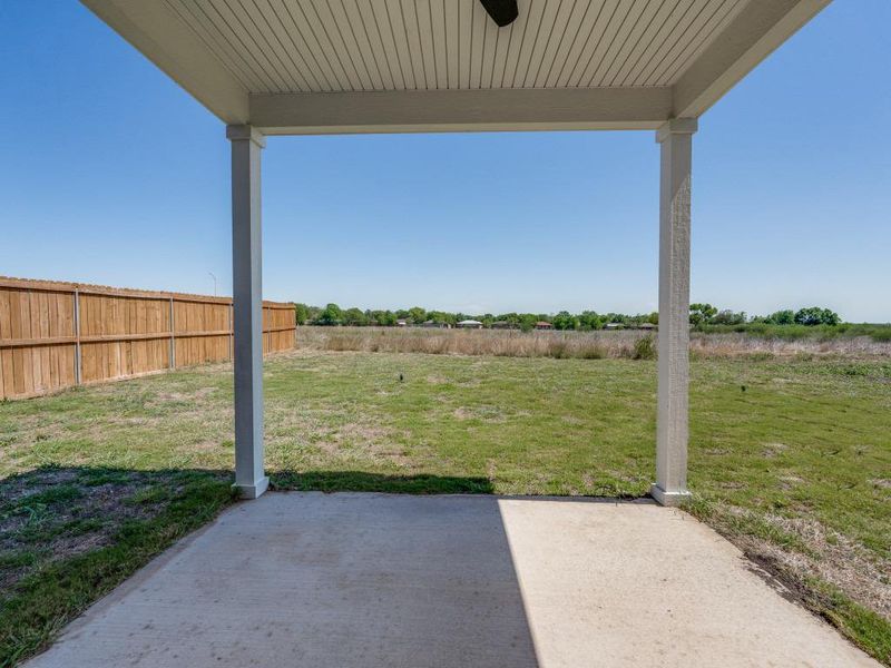 View of yard with a patio area, fence, and a ceiling fan