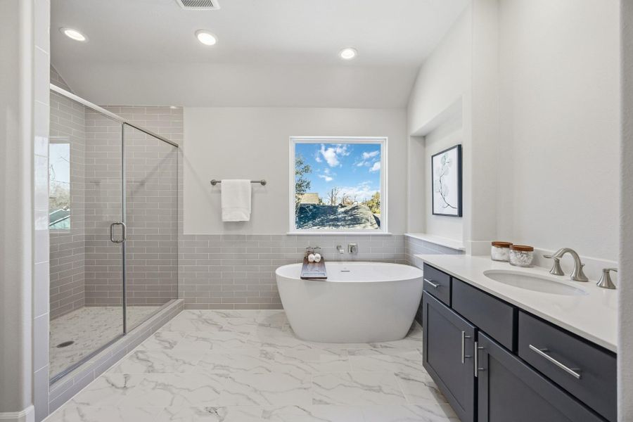 Ensuite Elegance: Step into the primary suite's ensuite bathroom, boasting abundant space and luxurious finishes, including a spa-like shower adjacent to the elegant freestanding tub.