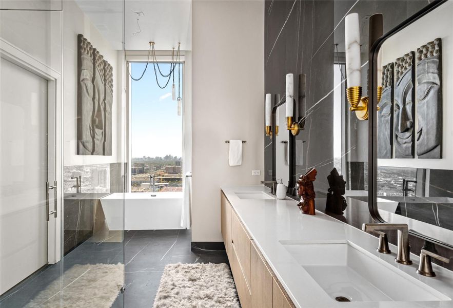 The primary bathroom boasts custom lighting, heated floors, and three walk-in closets, complemented by quartz countertops and a marble backsplash for a luxurious finish.