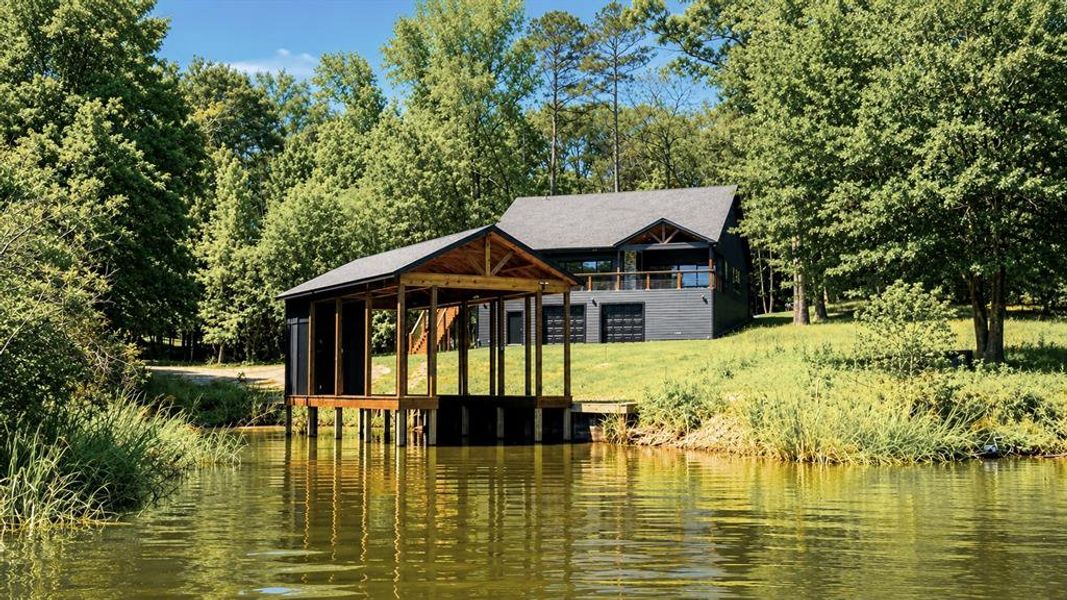 Waterfront property featuring a private boat dock with a covered slip and additional open storage