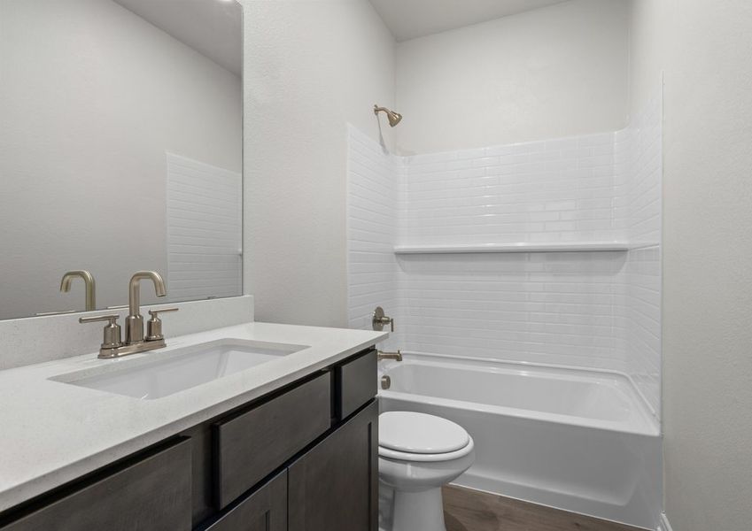 The secondary bathroom has a sprawling vanity and shower-tub combo.