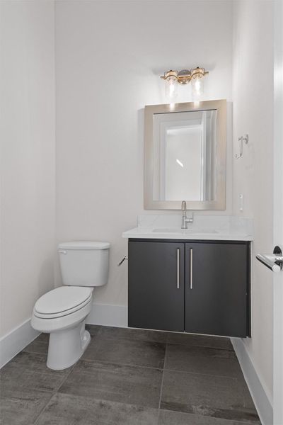 Half bathroom featuring vanity and baseboards Half bathroom featuring vanity and baseboards