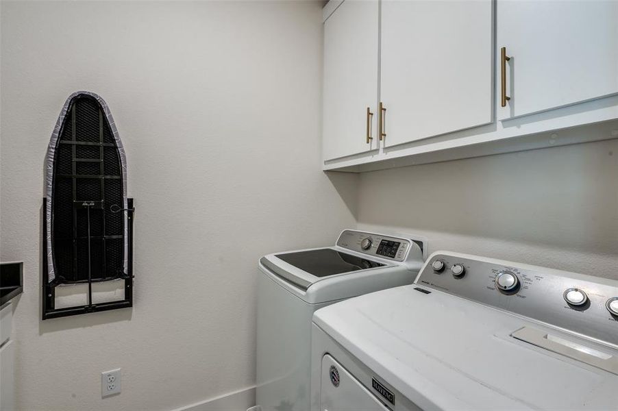 Convenient 2nd floor laundry room with sink, granite countertop folding area and storage cabinets.