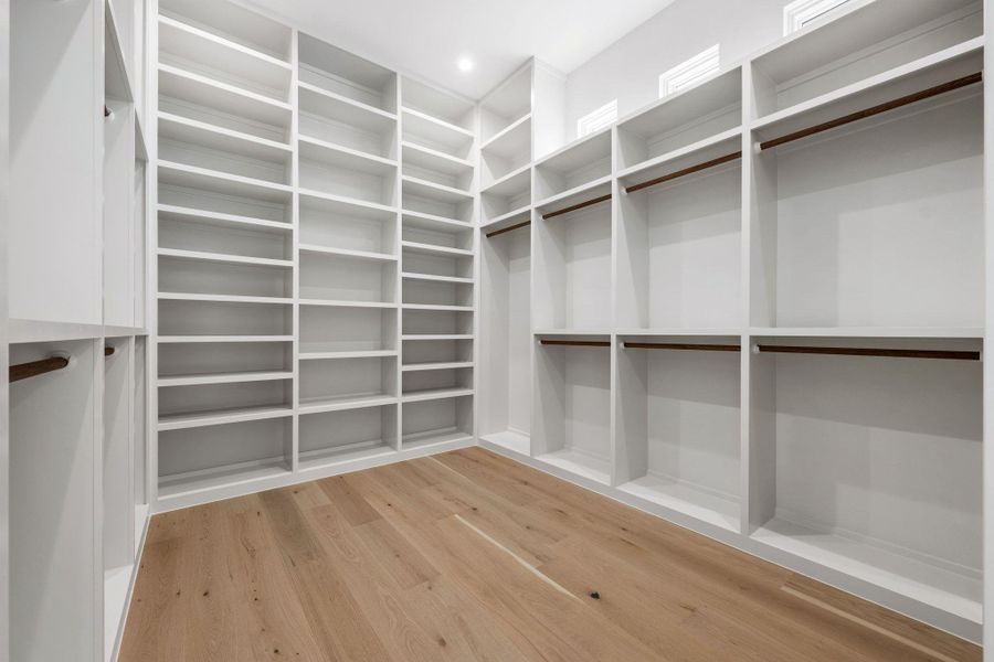 Spacious closet with light wood-type flooring Spacious closet with light wood-type flooring