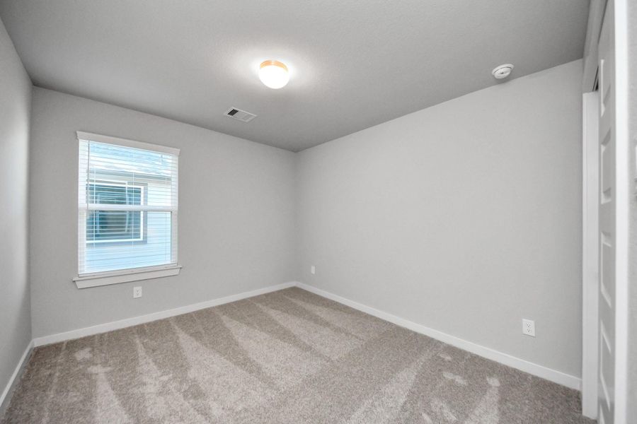 Generously sized secondary bedrooms featuring spacious closets, soft and inviting carpeting underfoot, large windows allowing plenty of natural light, and the added touch of privacy blinds for your personal retreat. Sample photo of completed home with similar floor plan. Actual colors and selections may vary.