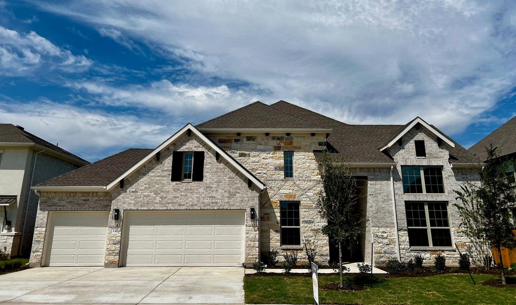 View of front facade featuring roof with shingles, driveway, stone siding, and an attached garage View of front facade featuring roof with shingles, driveway, stone siding, and an attached garage