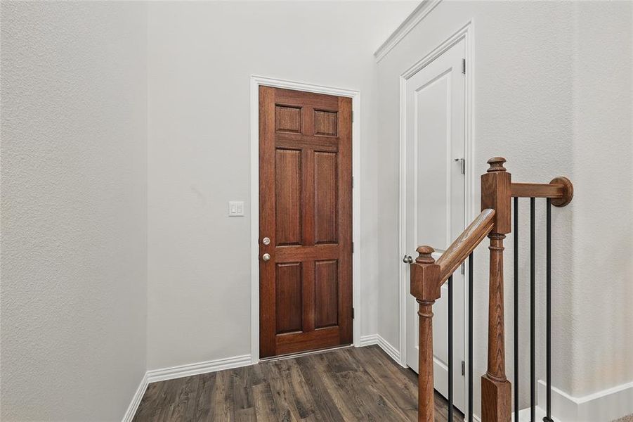 Entrance foyer featuring dark wood-style flooring and a textured wall