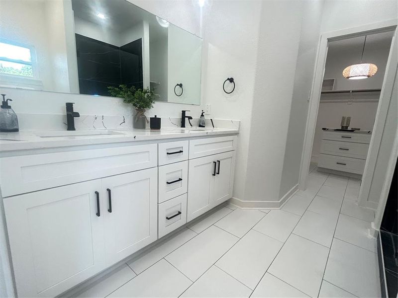 Bathroom with tile patterned floors and dual bowl vanity