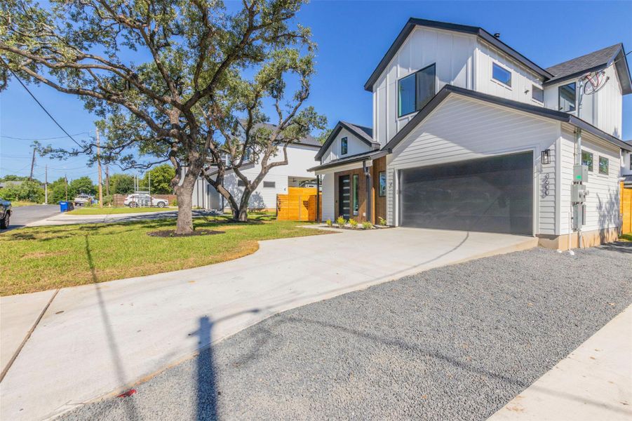 View of front of property with driveway, board and batten siding, and a front lawn
