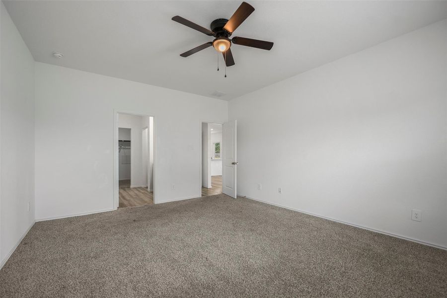 Spacious first-floor primary suite with walk-in closet and ensuite bath Spacious first-floor primary suite with walk-in closet and ensuite bath