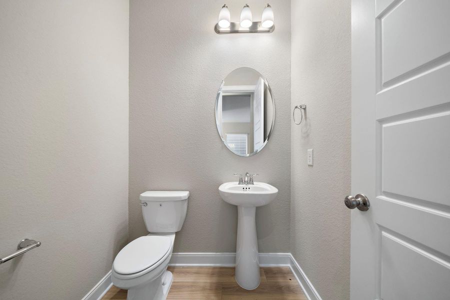 This sleek and stylish half-bath features a modern design, ideal for guests and conveniently located on the main floor.