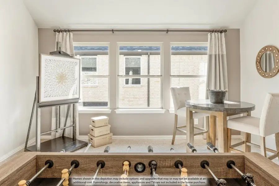 Game room with foosball table, small dining set, and three windows with neutral curtains Game room with foosball table, small dining set, and three windows with neutral curtains