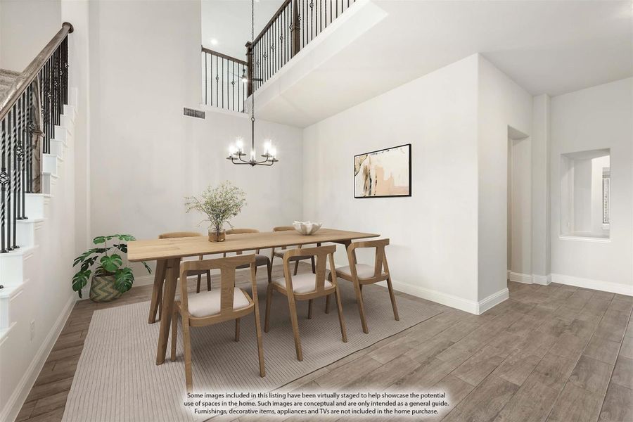 Dining room with two-story ceiling, wood table, six chairs, chandelier, and hardwood floors