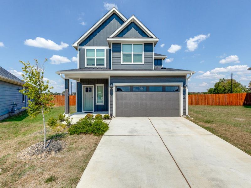 View of front of home featuring board and batten siding, a porch, a garage, and driveway