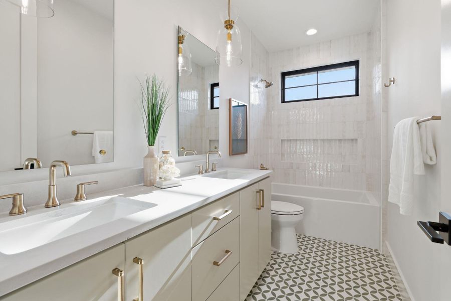 Bathroom featuring double vanity and shower / bath combination
