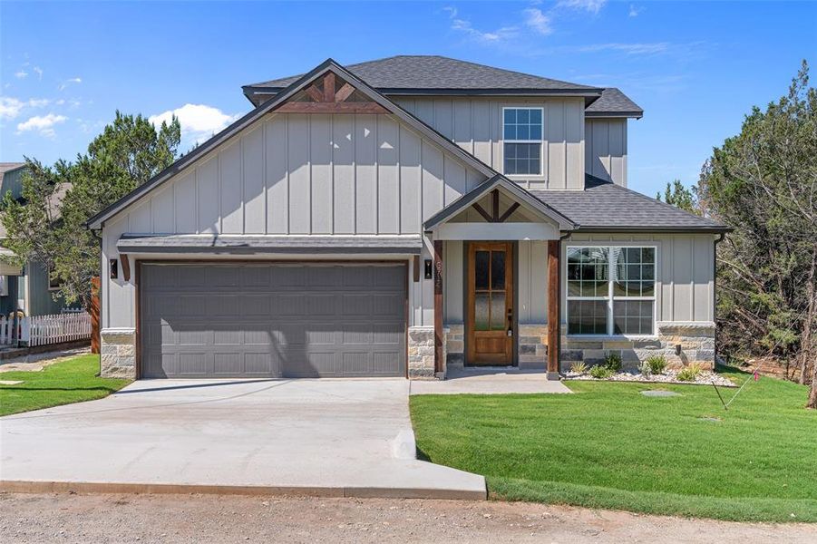 View of front of home with a garage and a front yard