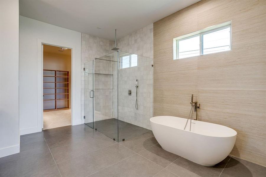 Full bath featuring a stall shower, tile patterned floors, and a freestanding bath Full bath featuring a stall shower, tile patterned floors, and a freestanding bath