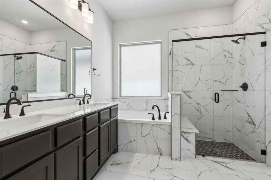 Bathroom featuring independent shower and bath, vanity, and a healthy amount of sunlight