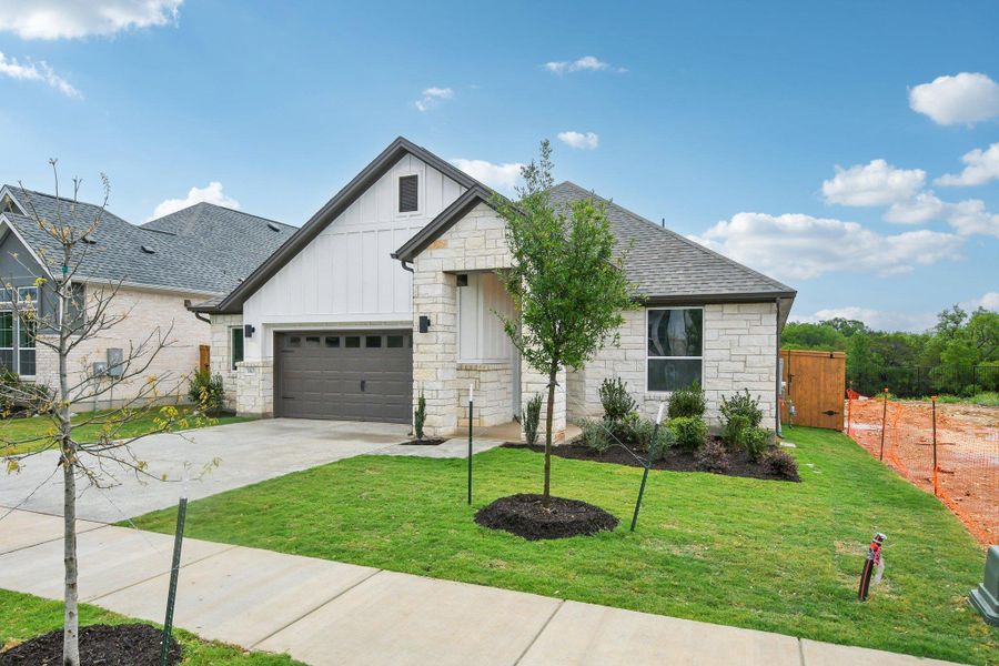 Front exterior of a new home in Persimmon, Buda, TX, highlighting curb appeal (Image 2). Front exterior of a new home in Persimmon, Buda, TX, highlighting curb appeal (Image 2).