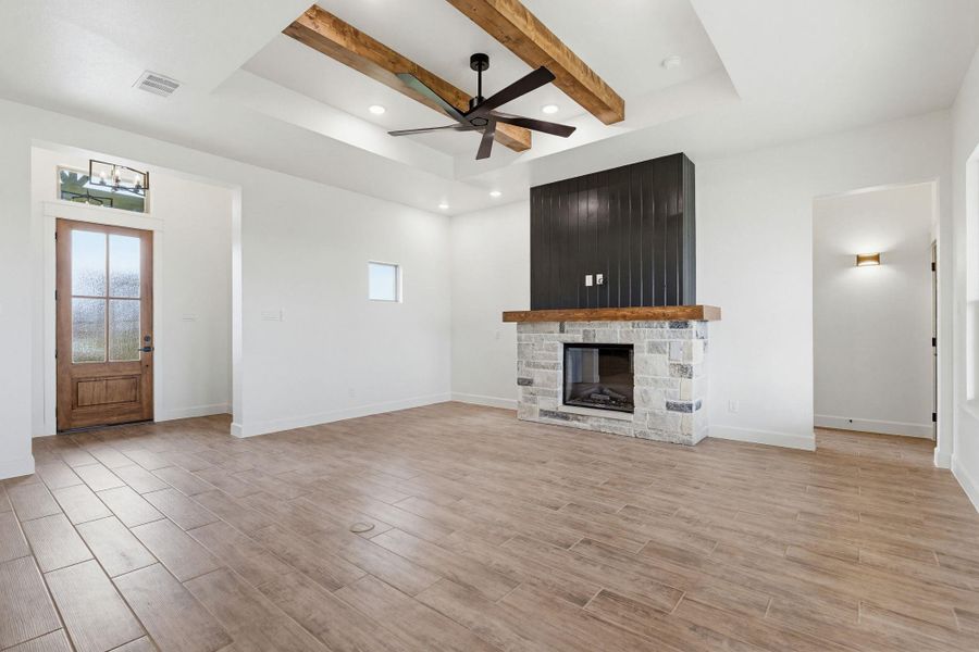 A welcoming entry opens to a spacious living room with a striking stone fireplace. A welcoming entry opens to a spacious living room with a striking stone fireplace.
