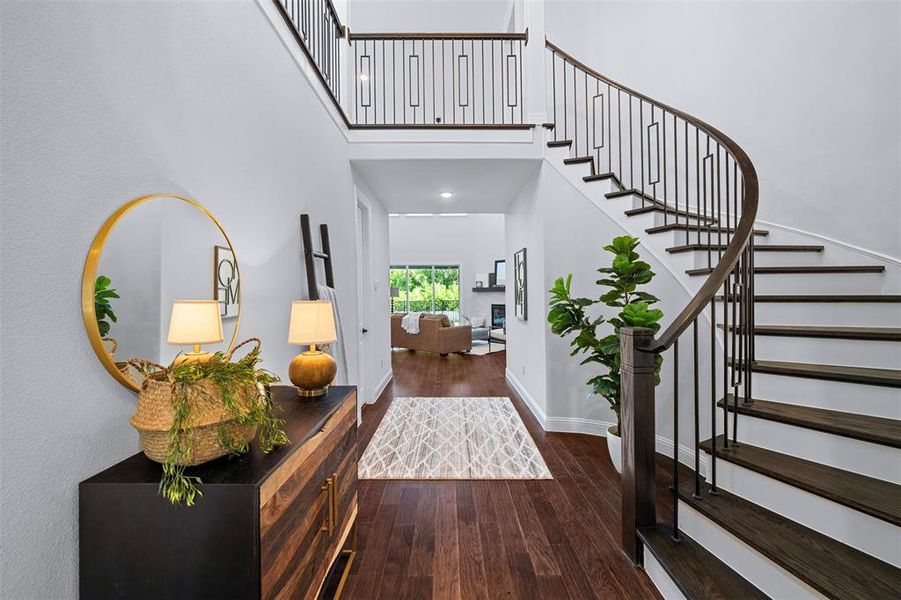 Foyer entrance featuring hardwood / wood-style floors, a high ceiling, and stairs